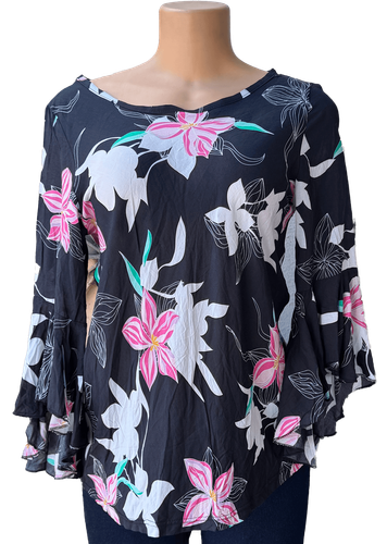 Vista de frente (dos de dos). Una blusa negra de manga larga con un estampado de flores en tonos blancos, rosas y verdes.