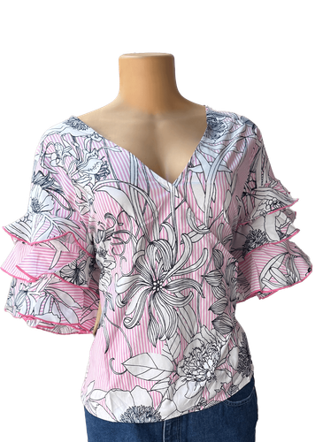 Vista de frente (dos de dos). Blusa manga corta con diseño floral con detalles delicados.