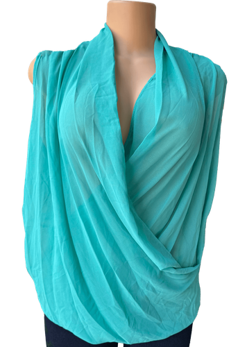 Vista de frente (dos de dos). Una blusa de gasa con un diseño drapeado, sin mangas y con un escote pronunciado.