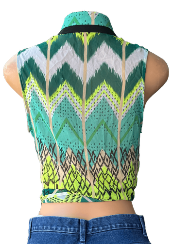 Vista de espalda. Una blusa sin mangas con un diseño de patrones geométricos en tonos verdes y un nudo frontal.