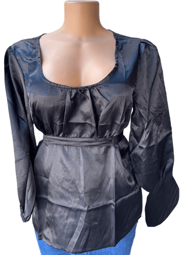 Vista de frente (dos de dos). Una blusa negra simple con mangas largas y un cinturón ajustable en la cintura.