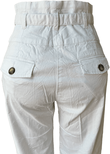 Vista de atrás (dos de dos). Pantalón blanco de talle alto con múltiples botones decorativos en la parte delantera.