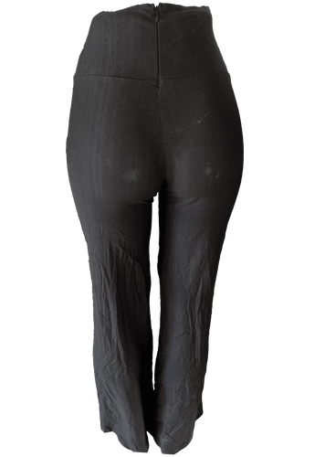 Pantalón estrecho de color negro con cierre trasero y una correa decorativa en el frente. Vista de atrás.