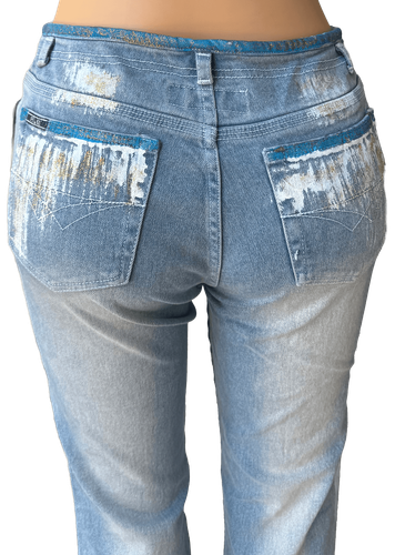 Espalda (dos de dos) - Pantalón de mezclilla azul claro con un diseño único de manchas de pintura en los bolsillos traseros y a lo largo de las piernas.