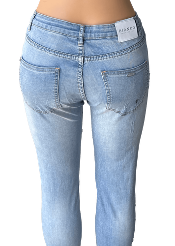 Pantalón de mezclilla claro con detalles de desgaste y rasgaduras en la parte frontal y trasera. Bolsillos traseros lisos con costuras visibles y un parche de la marca en la parte trasera.